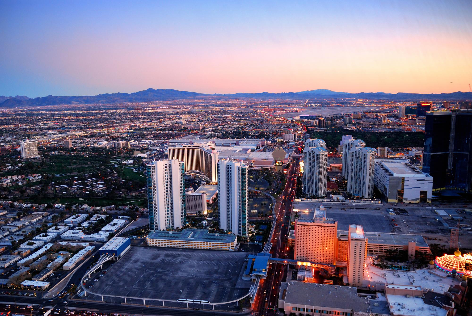 Aerial shot of downtown Las Vegas during sunset, mountains in back, city in front 