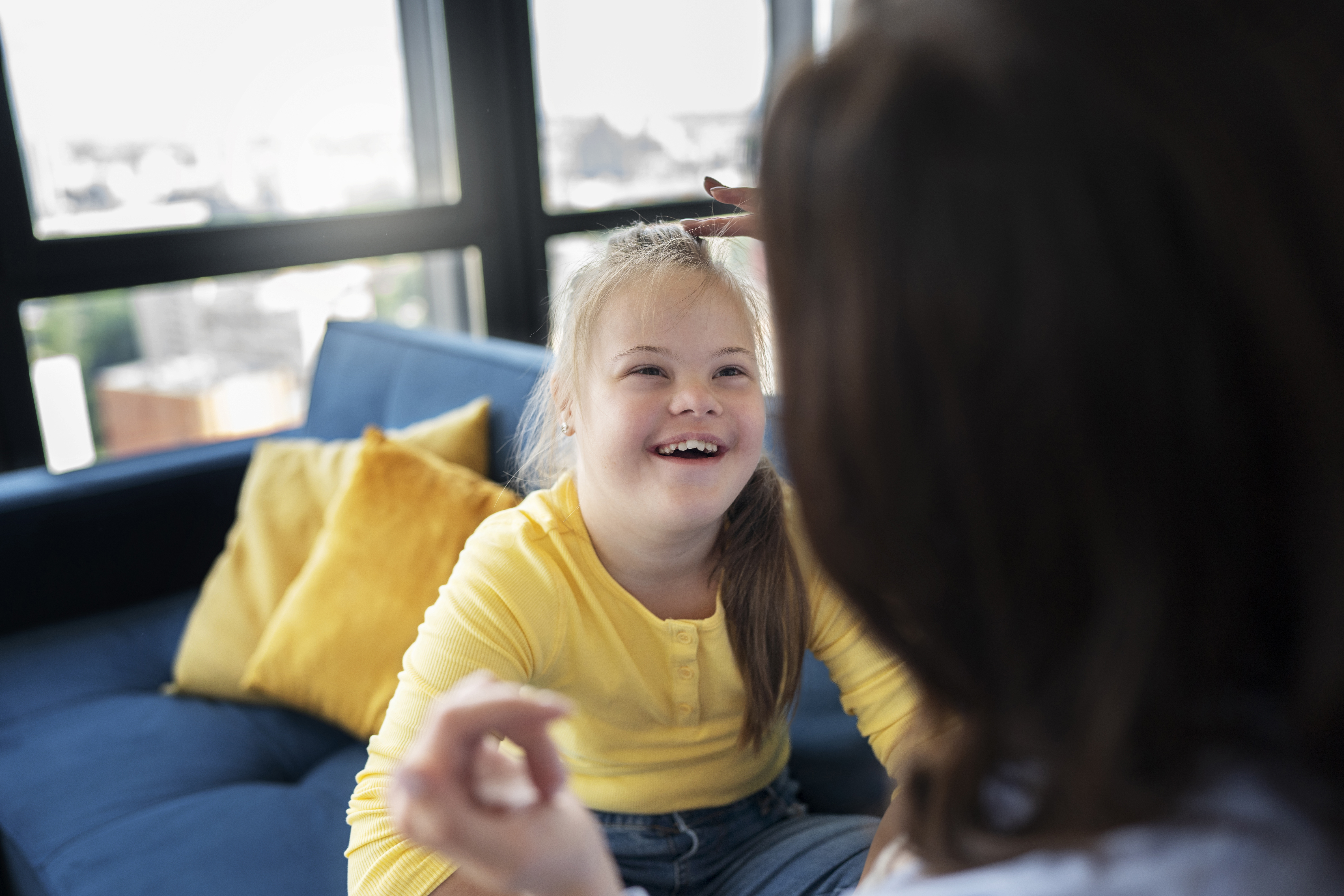 Smiley and happy Girl With Down Syndrome wearing bright yellow shirt. 