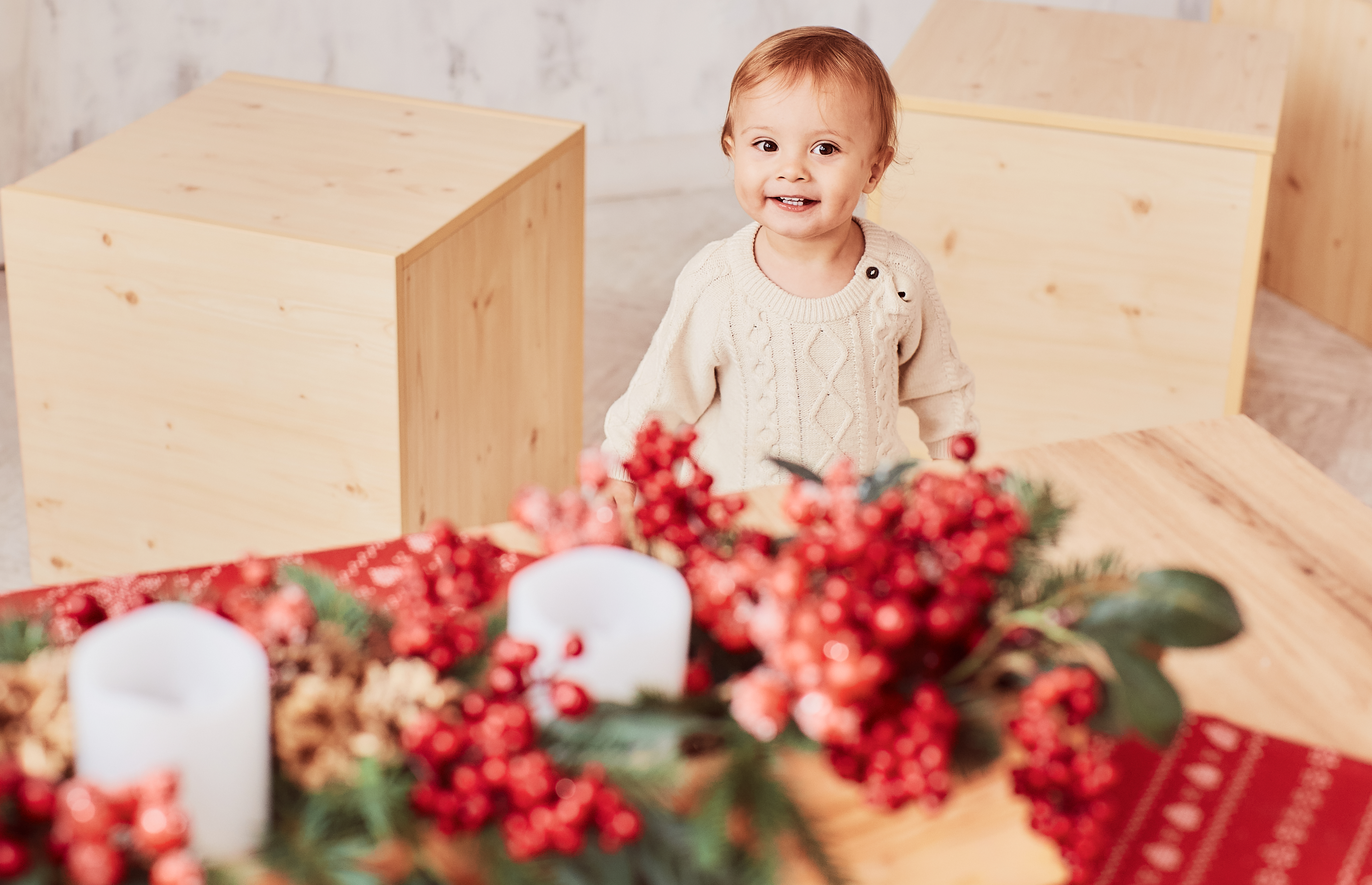 Cute litte girl smiles while standing in a room with holiday decorations around her