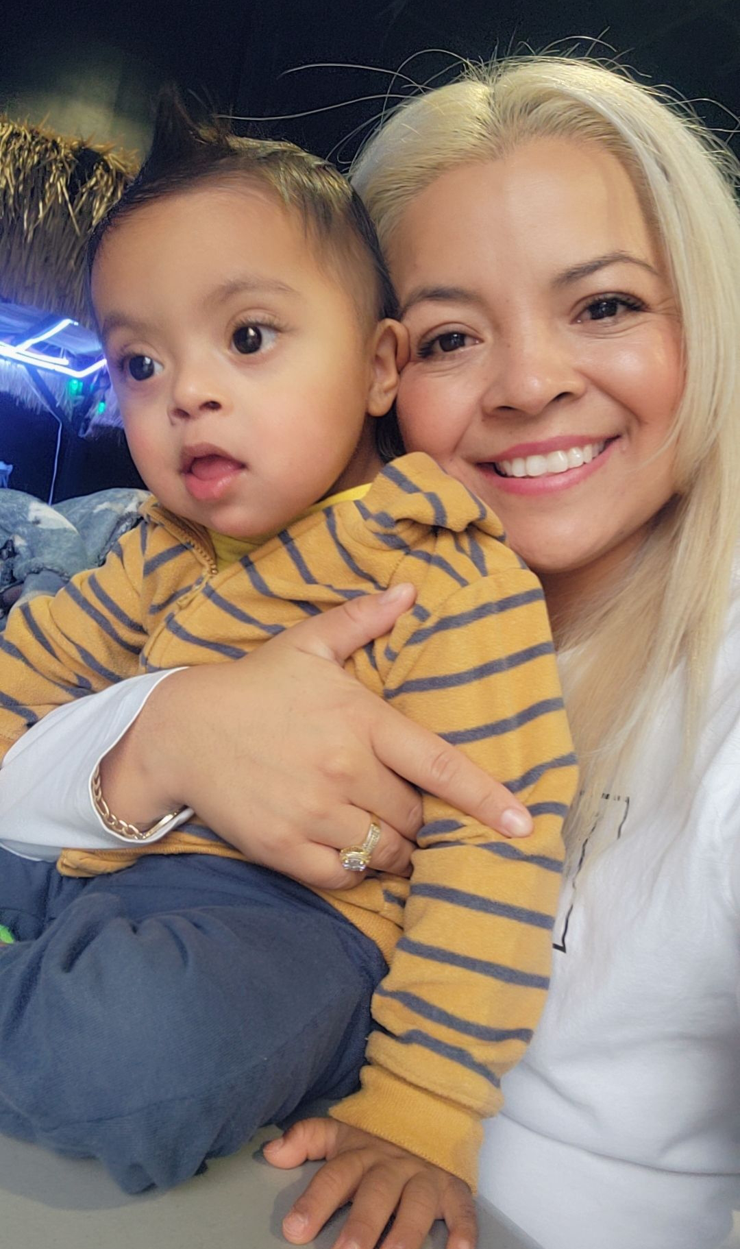 Ana Elizabeth Saucedo Gutierrez holding baby and smiling at camera 
